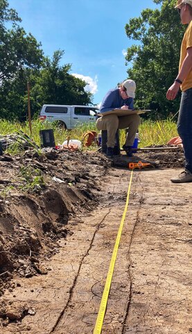 Caitlyn Antoniuk (seated) mapping one of the house structures